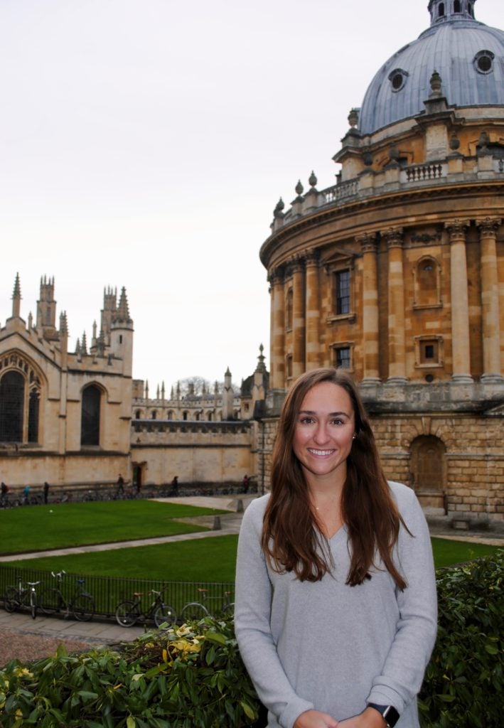 Anna Schildmeyer stands in front of the University of Oxford buildings in England.