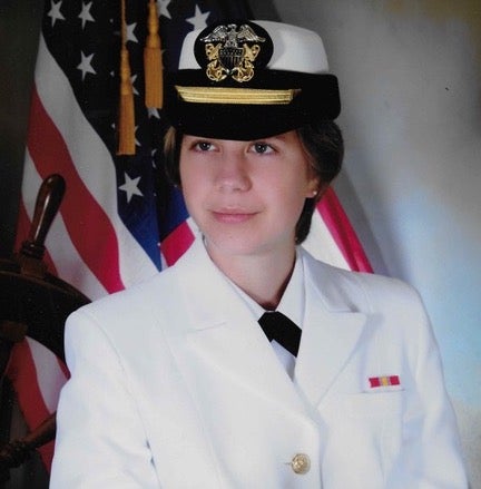 Cassie Bronson in uniform of U.S. Navy in front of U.S. flag
