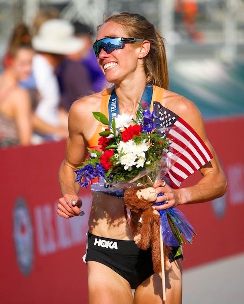 Rachel Schneider carried a flag of the United States and flowers 