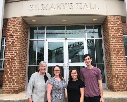 Standing in front of St. Mary's Hall, the home of the School of Nursing & Health Studies are: Dr. Diane Davis, Vanessa Taylor, Halyn Orellana (NHS’22) and JoJo Farina (C’23)