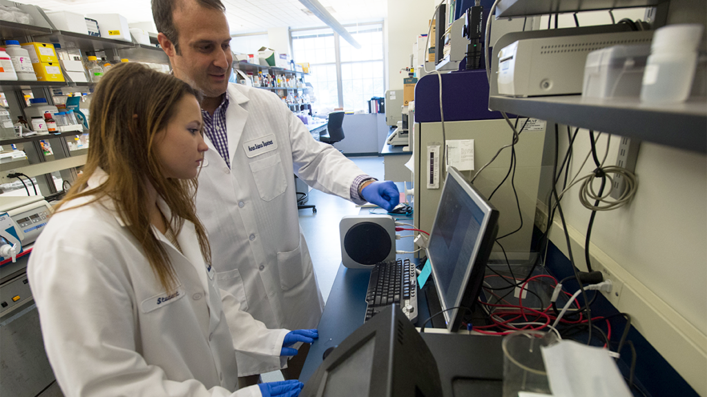 A professor and student work in a lab