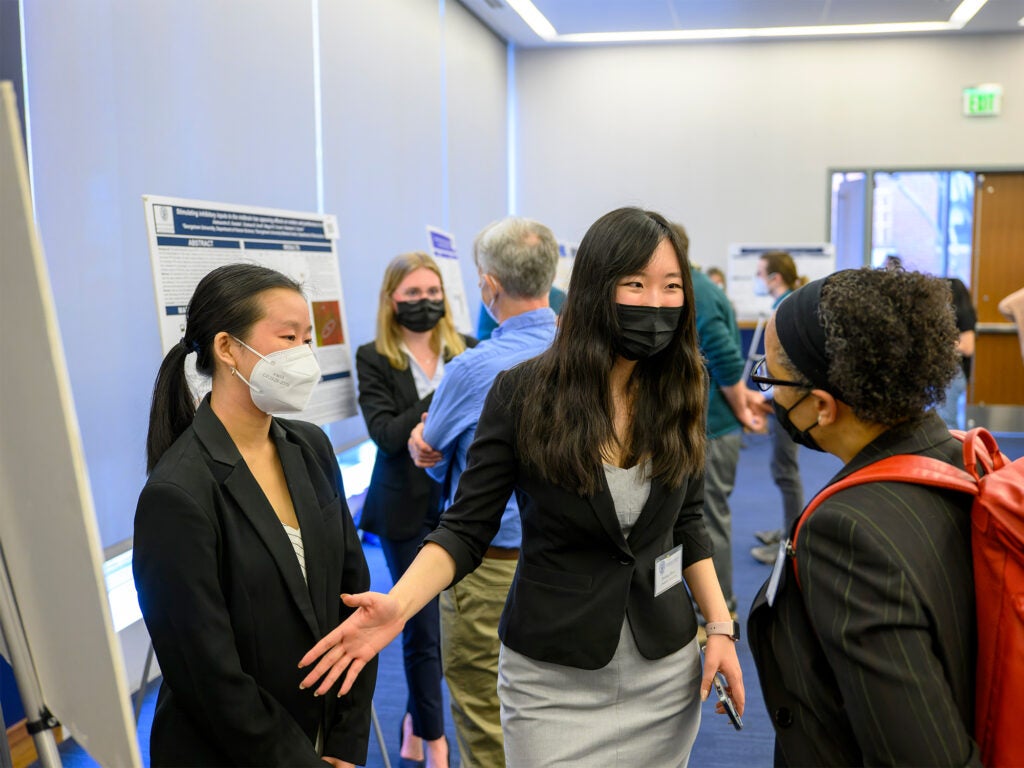 A woman explains her poster to another woman