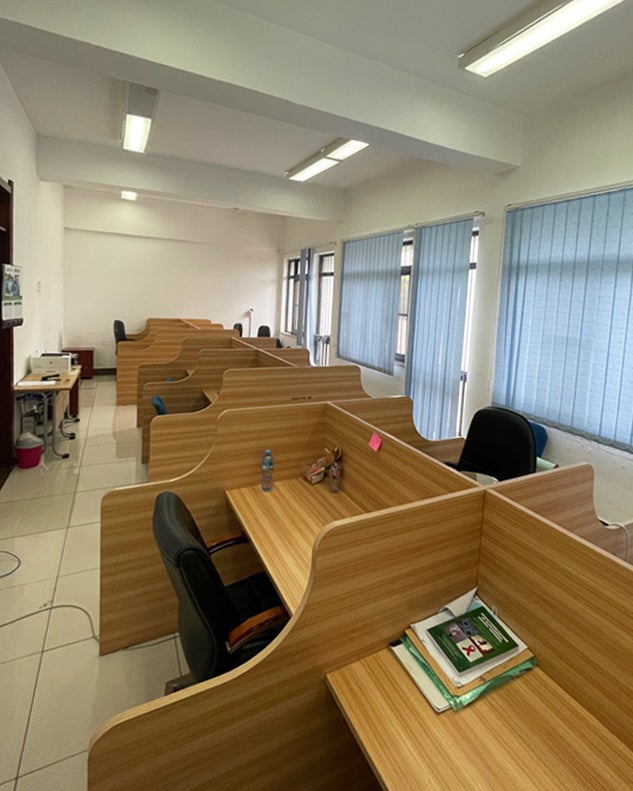 Multiple wooden desk carrels in an open room