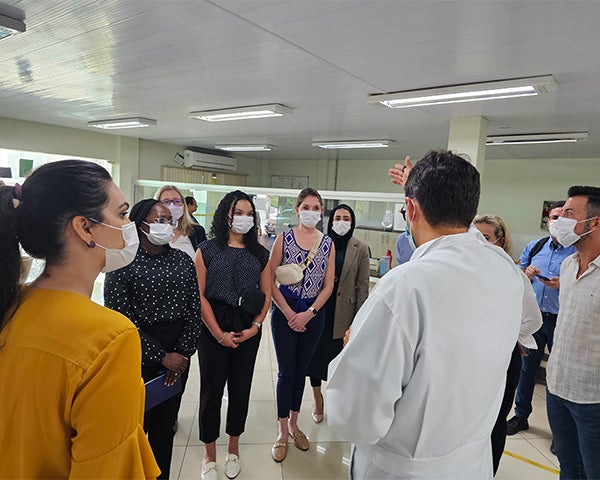 Students stand and listen as a doctor speaks to them