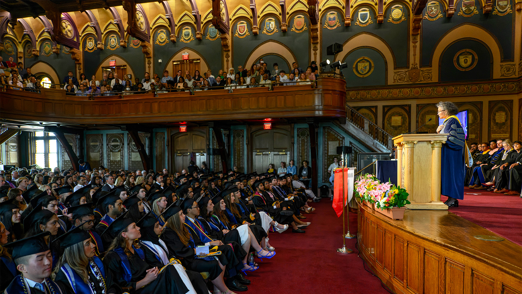 Graduates of the School of Health fill Gaston Hall while listening to commencement speakers on stage