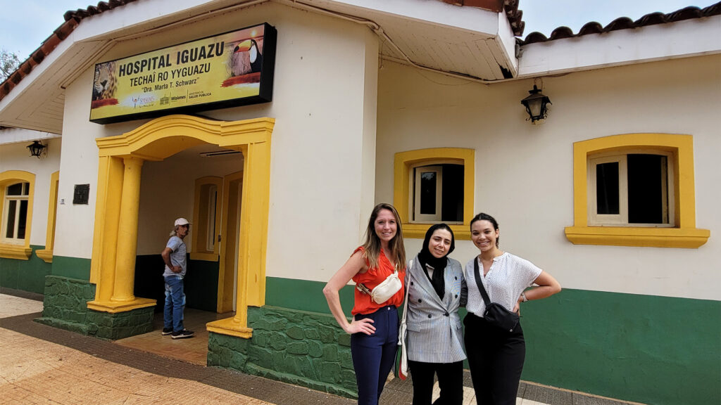 Three master's students stand in front of a hospital in Argentina that was part of the field experience on the annual global experience trip to South America.