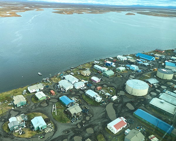 Aerial view of the Alaska town of Kivalina showing its isolation by water and mountains in the distance