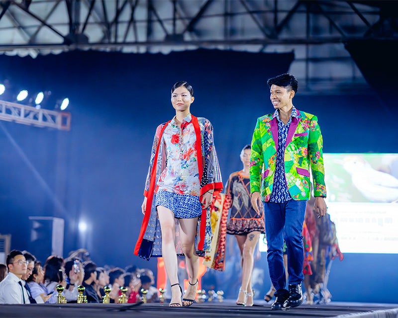 Two models walk the stage at a fashion show