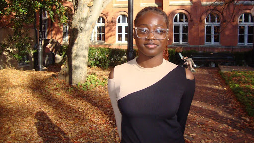 Fathia Fasasi (H'27) standing outside of a campus building in the Fall