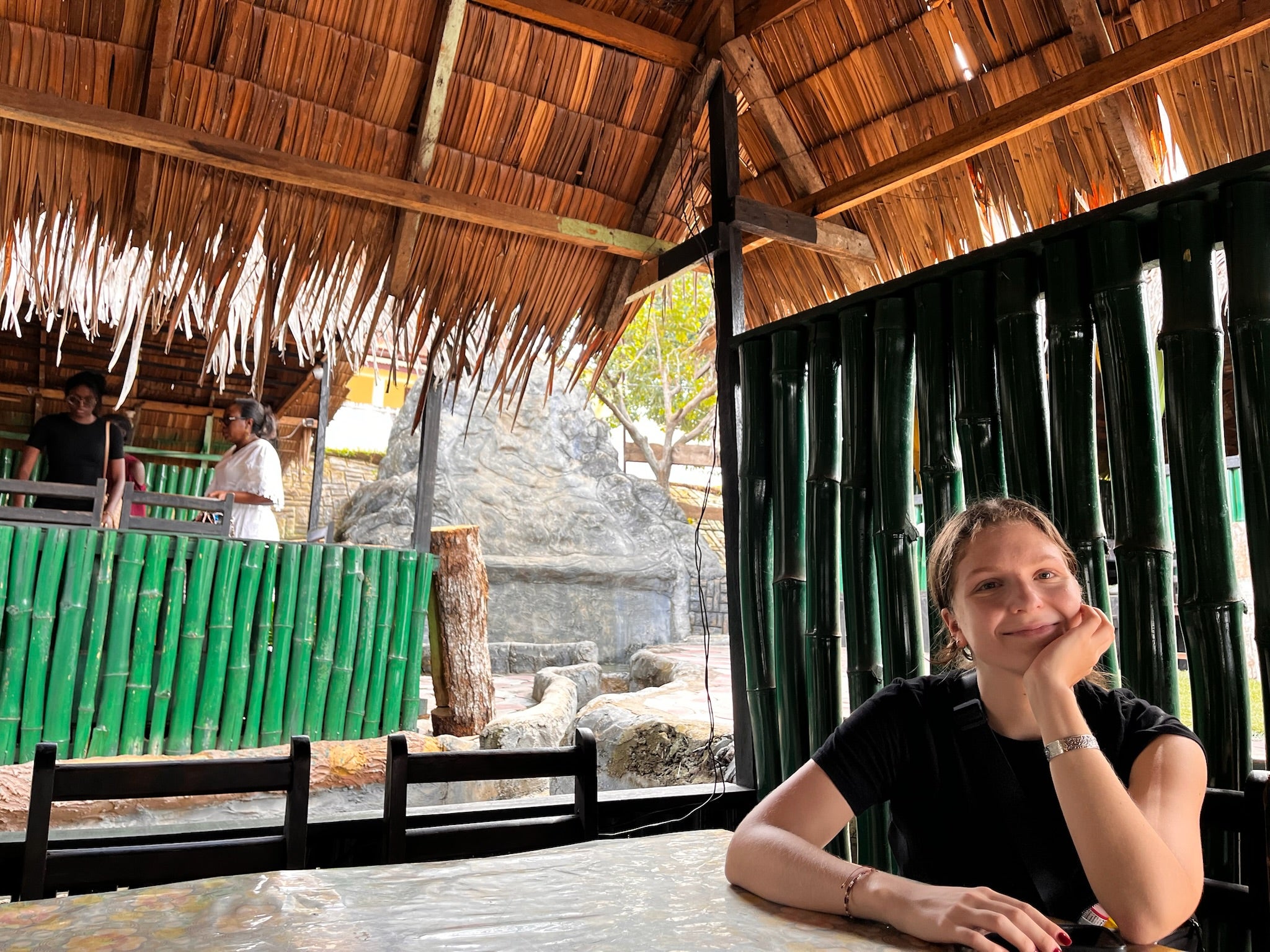 A student sits in a thatched structure