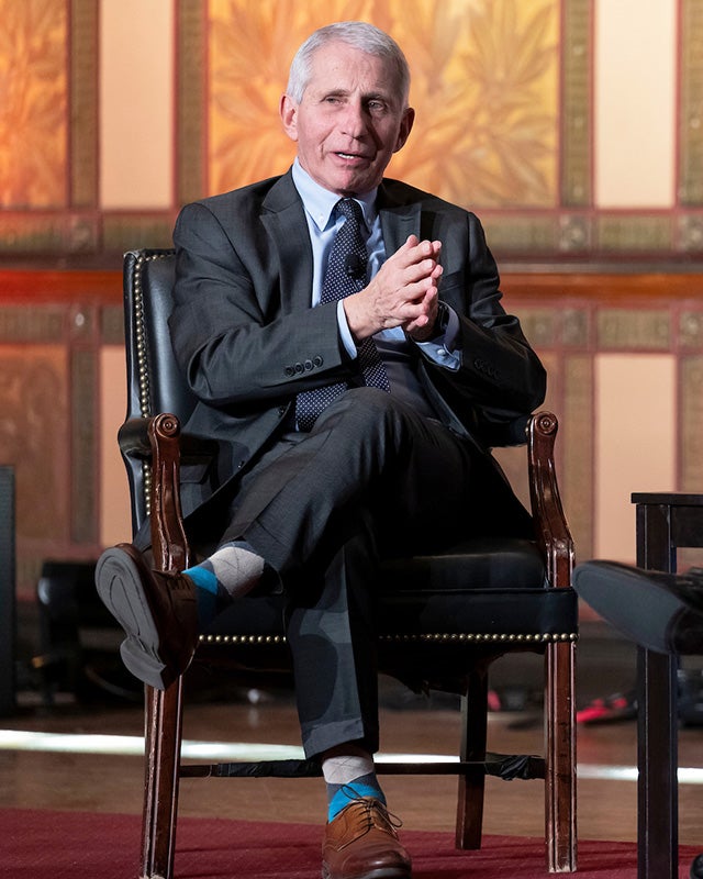 Anthony Fauci speaks from a chair onstage in Gaston Hall