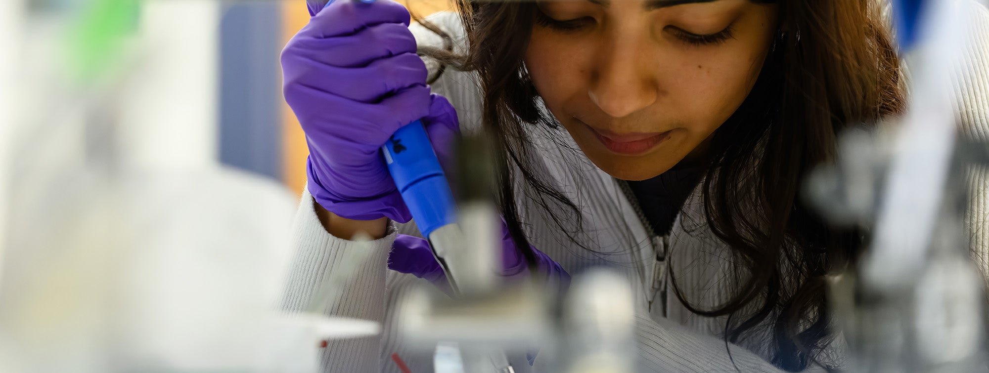 Closeup view of a student working with a pipette in the Discovery Center