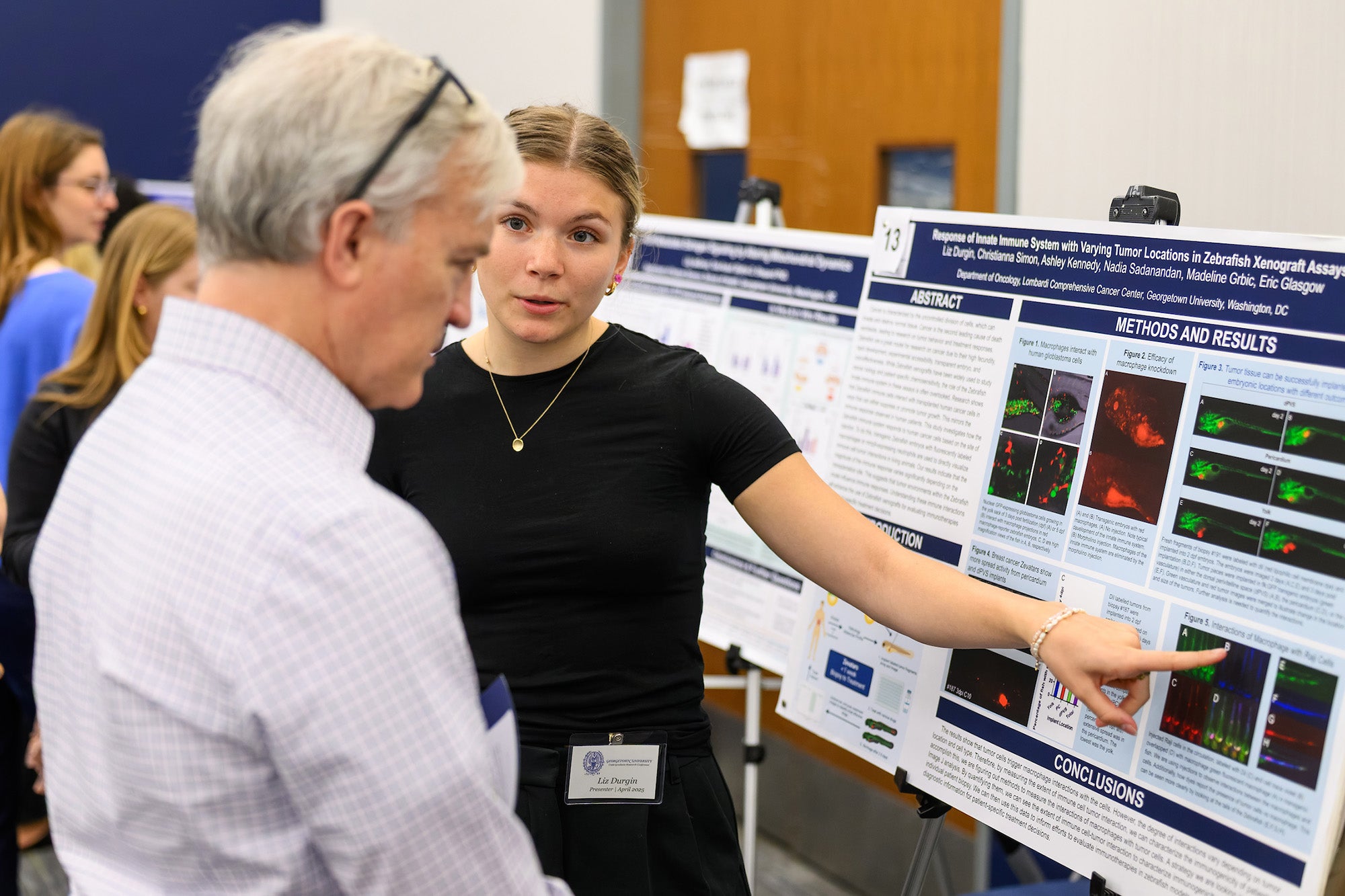 Liz Durgin explains her poster to a man