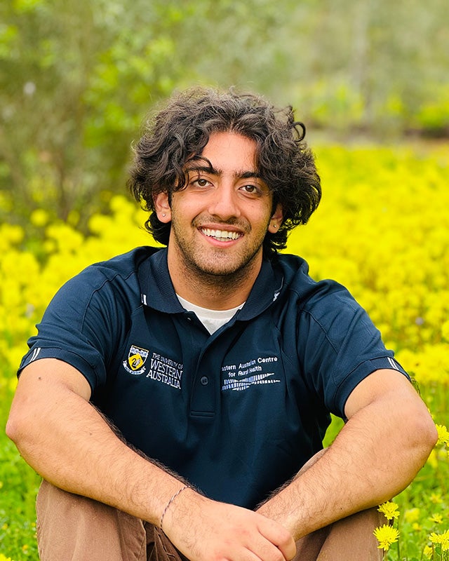 Argun sits in a field filled with yellow flowers