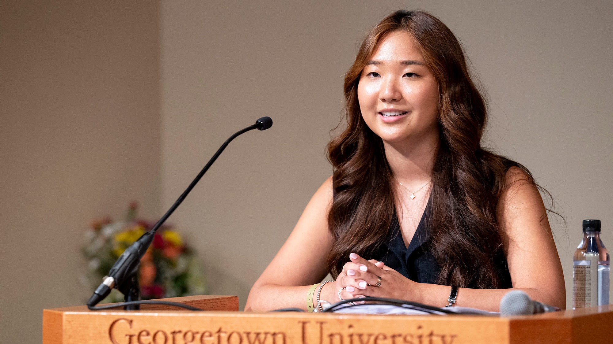 A female student speaks from a podium