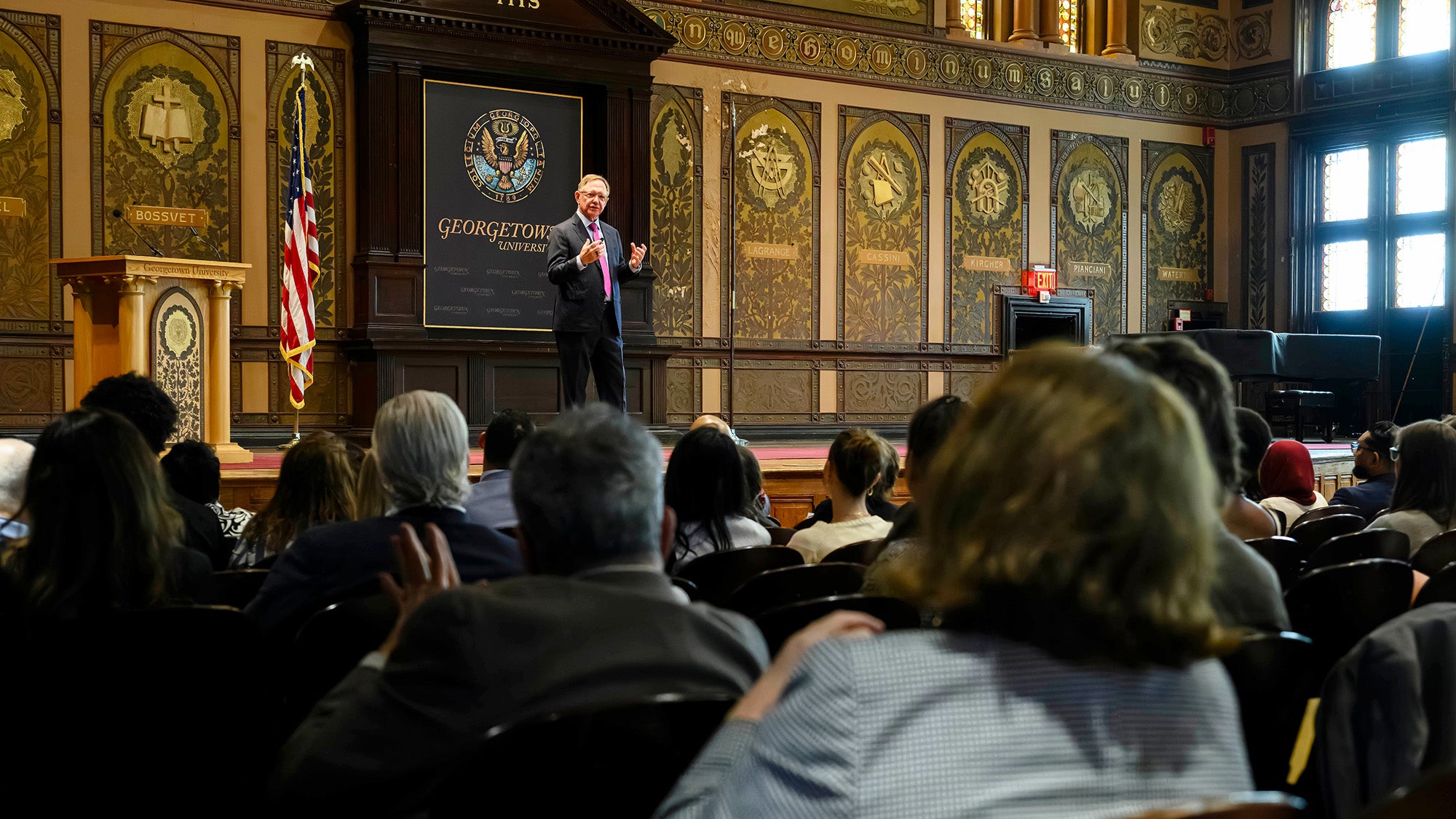 Quint Studer speaks from the stage in Gaston Hall