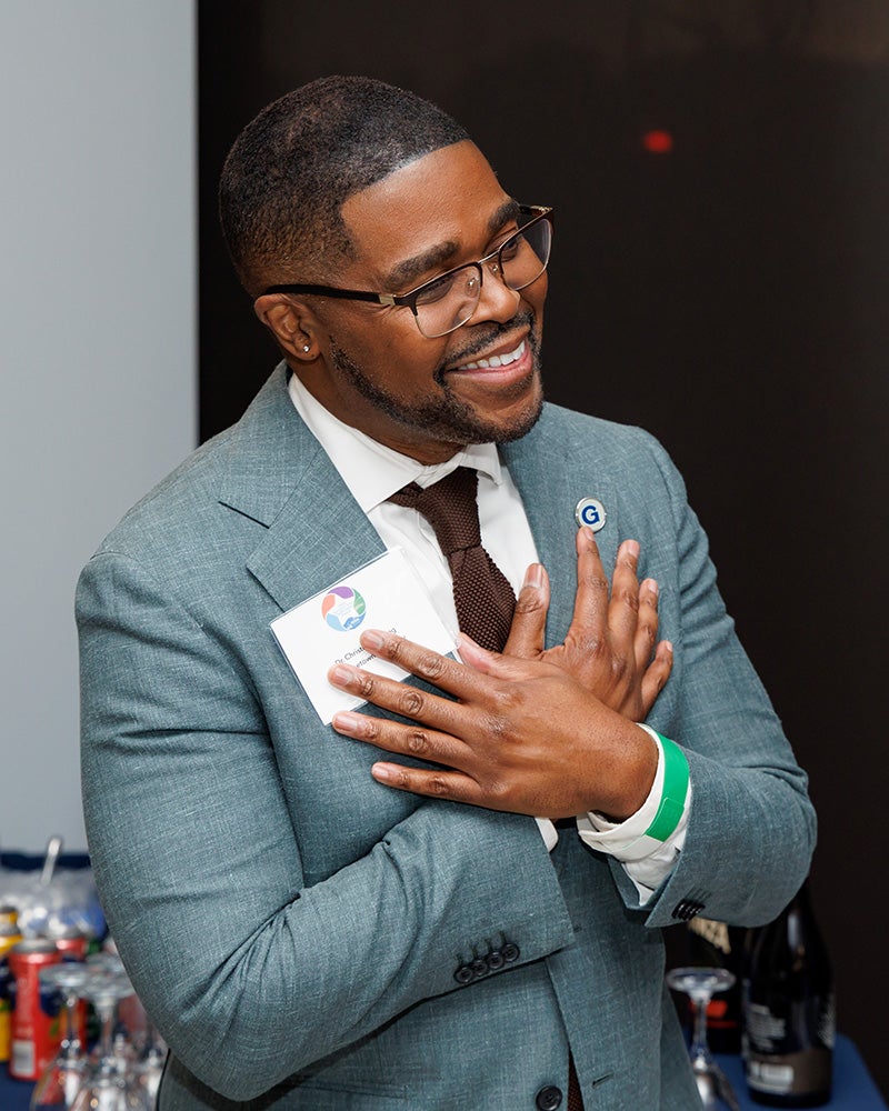 Dr. King crosses his arms at his chest in a gesture of gratitude