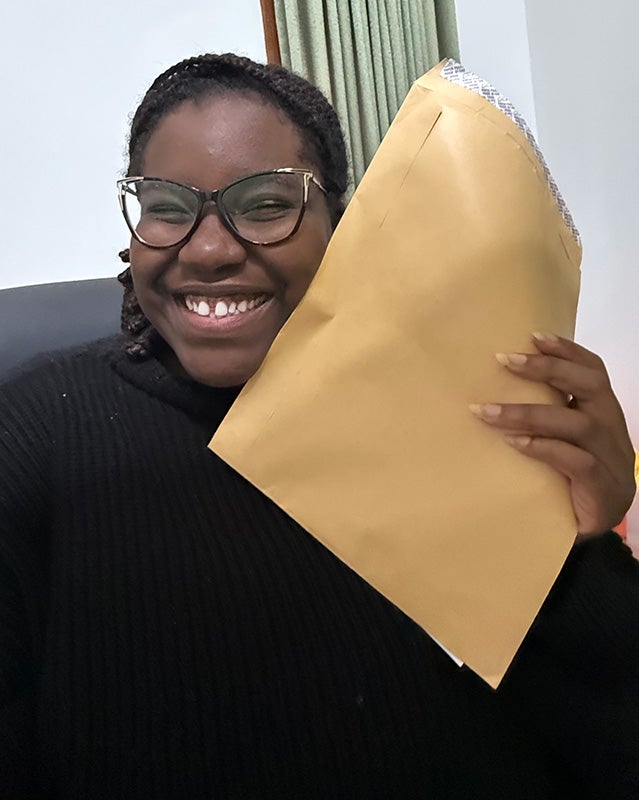 Tara-Yesomi Wenegieme poses with an envelope in her hand