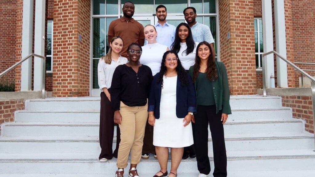 A group of first year MHSA students stands together on the steps of St. Mary's Hall