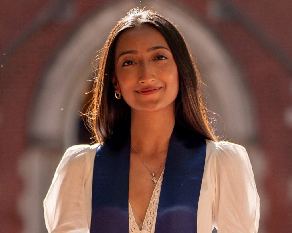 Shagun Gandhi stands in front of Dahlgren Chapel wearing a blue stole