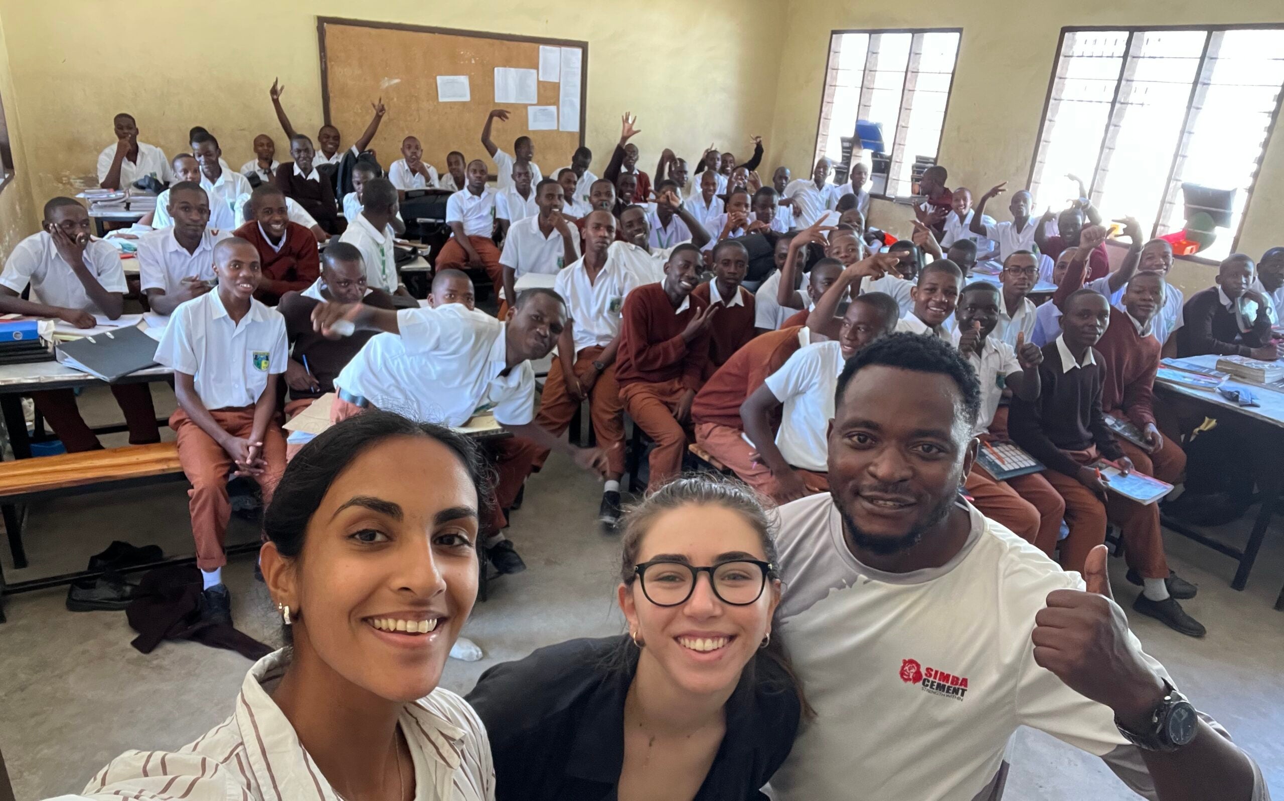 Undergrad global health students with colleagues in classroom in Tanga, Tanzania