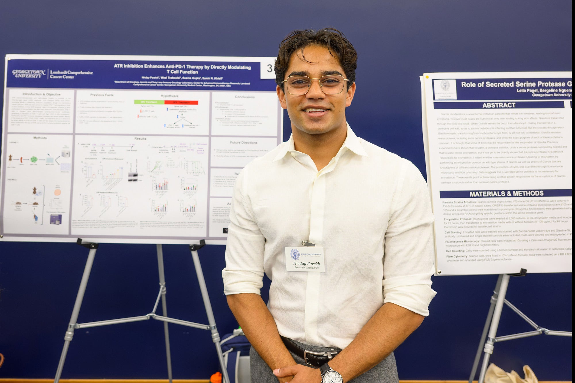 A student stands in front of his poster