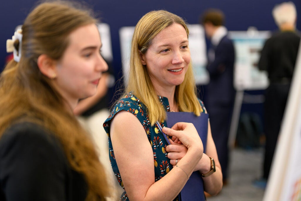 Jan Laroque stands with a student