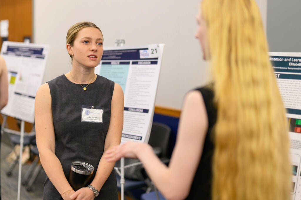A student converses with another student at the conference