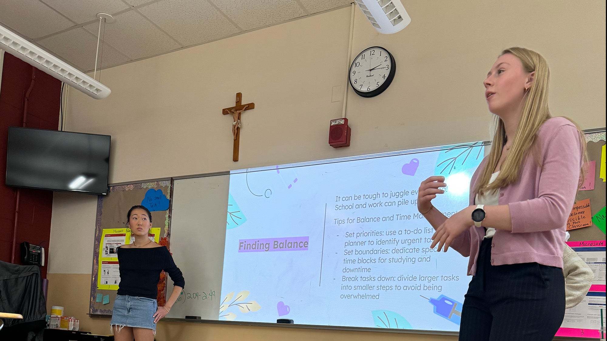 Two Georgetown students teach a lesson in a high school classroom