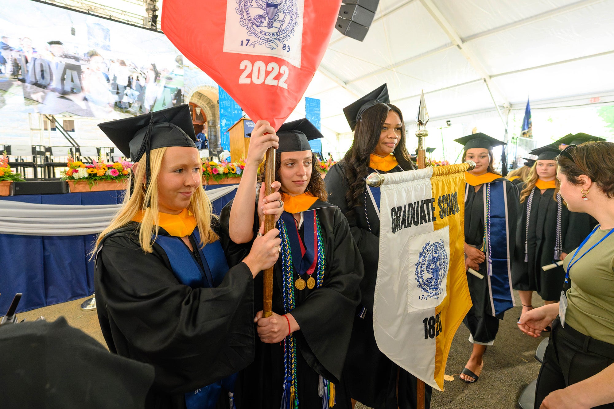 Students carry the school banners into the ceremony