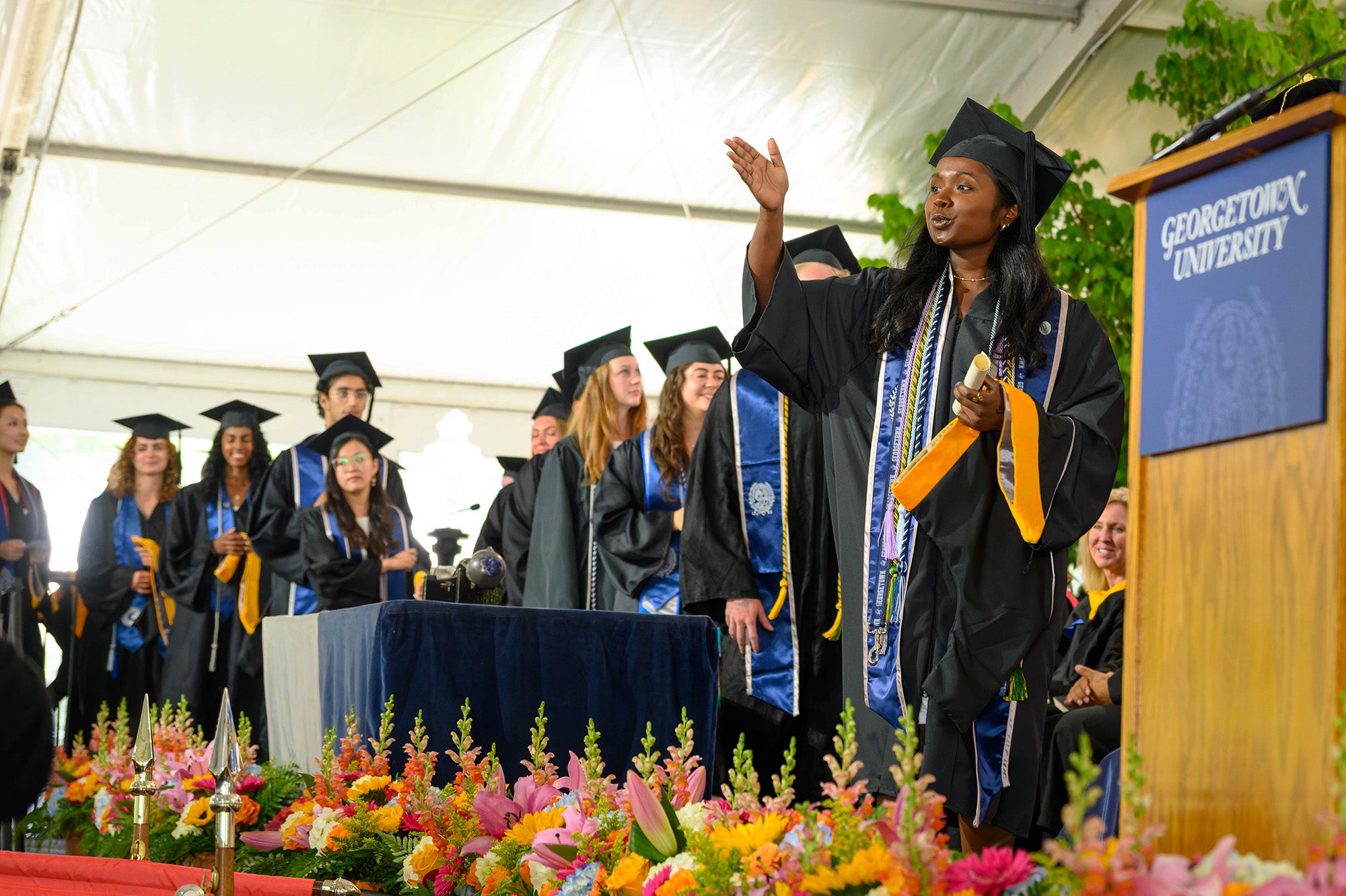 A student blows a kiss from the stage