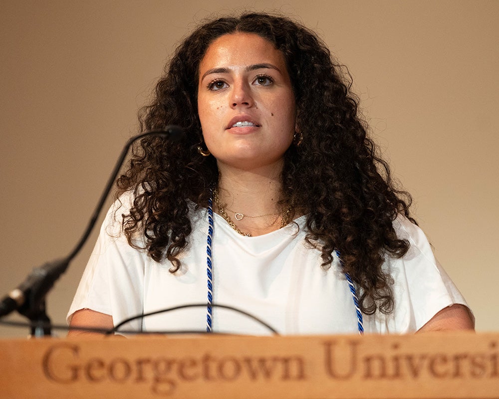 Tala Assaf speaks from a podium