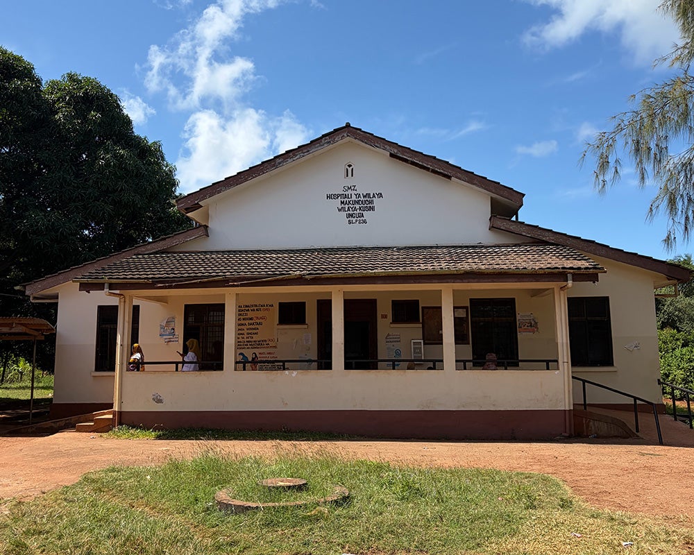 A stuccoed building with red tile roof and front porch