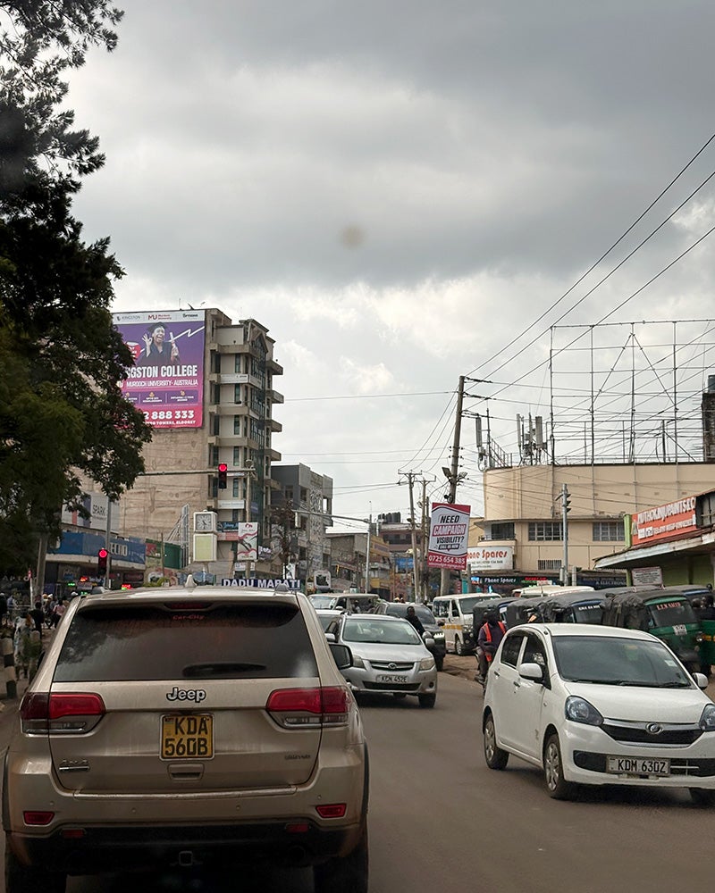A car-filled street lined with buildings in Nakuru, Kenya