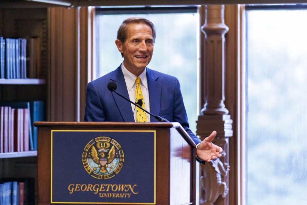 Mark Clement standing behind a Georgetown University podium and speaking.
